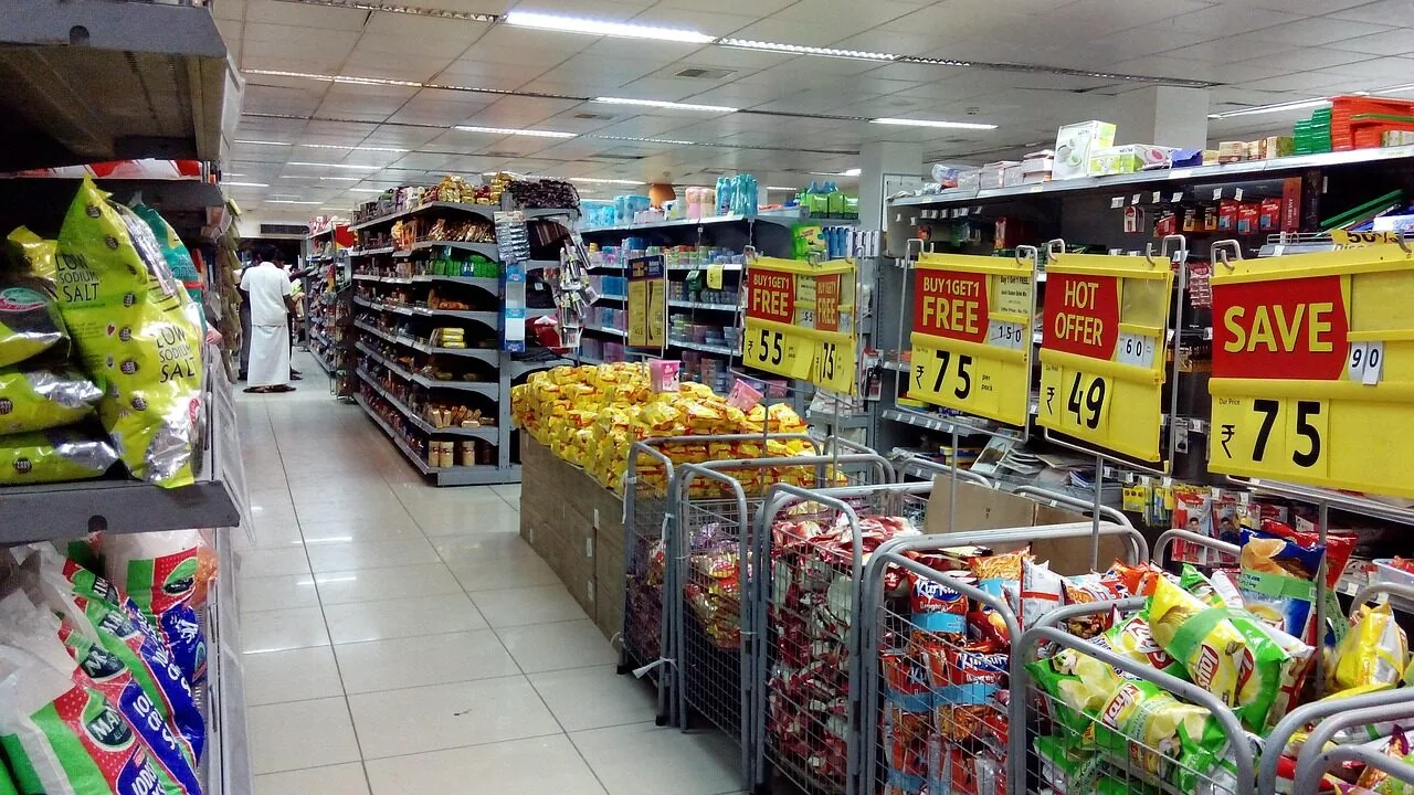 Customer reviewing receipt and comparing grocery prices while shopping at warehouse store