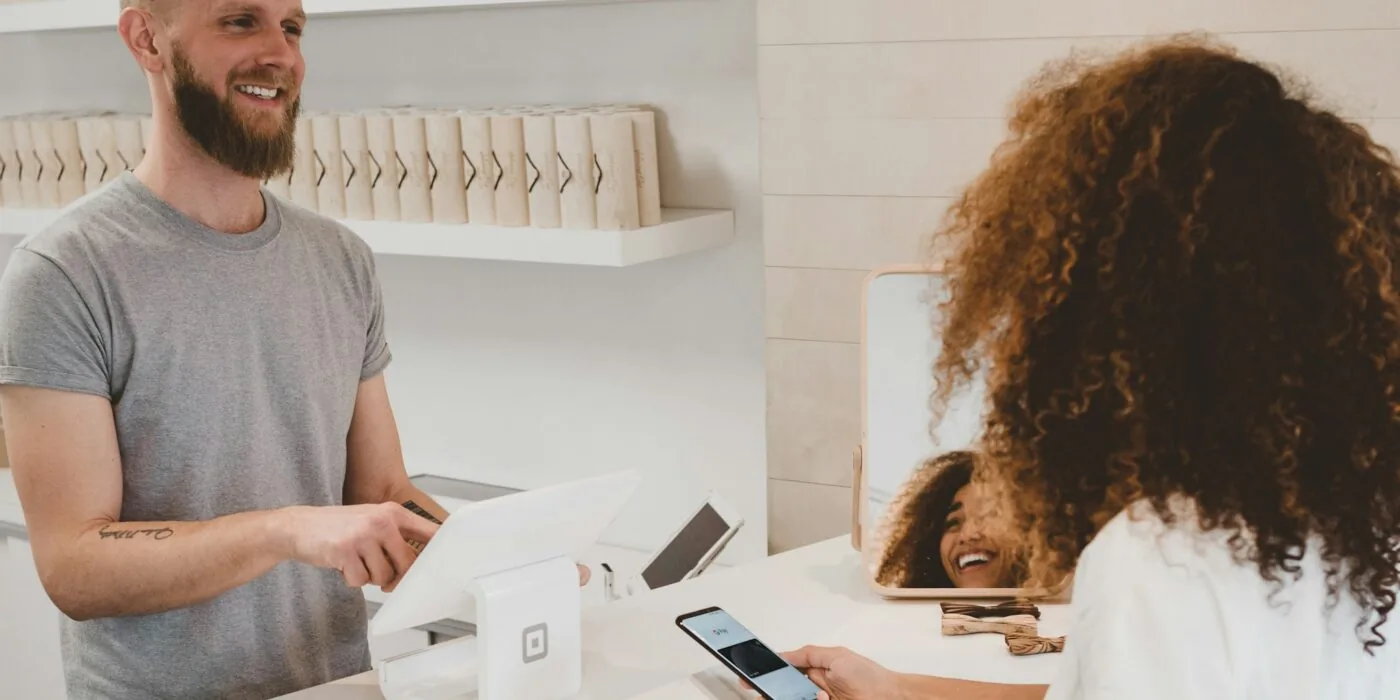 Person reviewing shopping receipt and comparing prices at store checkout counter