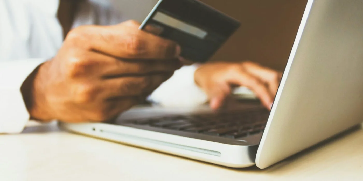 Shopper reviewing cart items on laptop, comparing shipping costs and offers during checkout