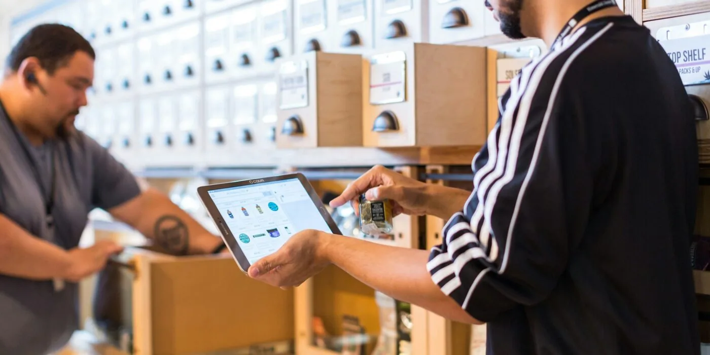 Small business owner reviewing order calculations and inventory costs at desk with laptop