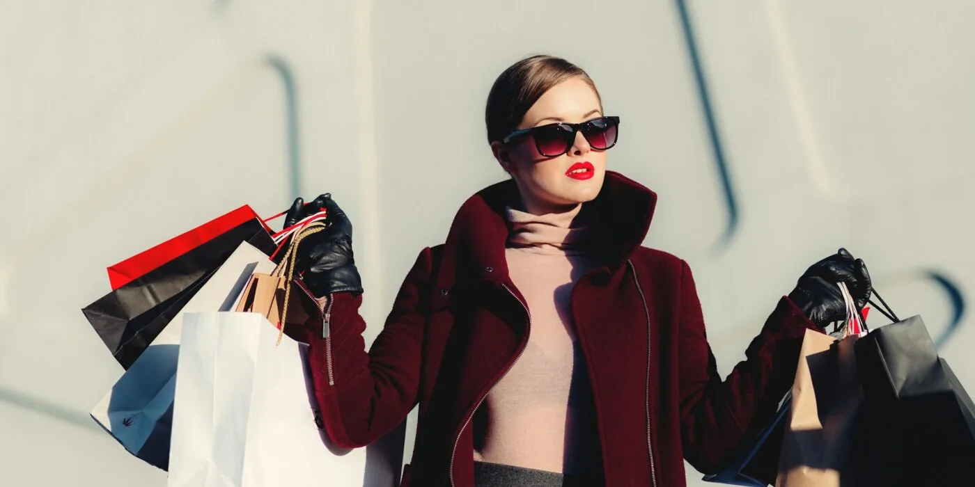 Woman browsing through clothing racks while shopping for seasonal discounts and sales